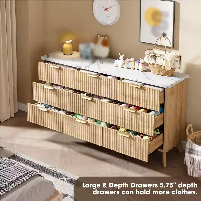 Une commode à neuf tiroirs dans la chambre à coucher, avec des poignées dorées.